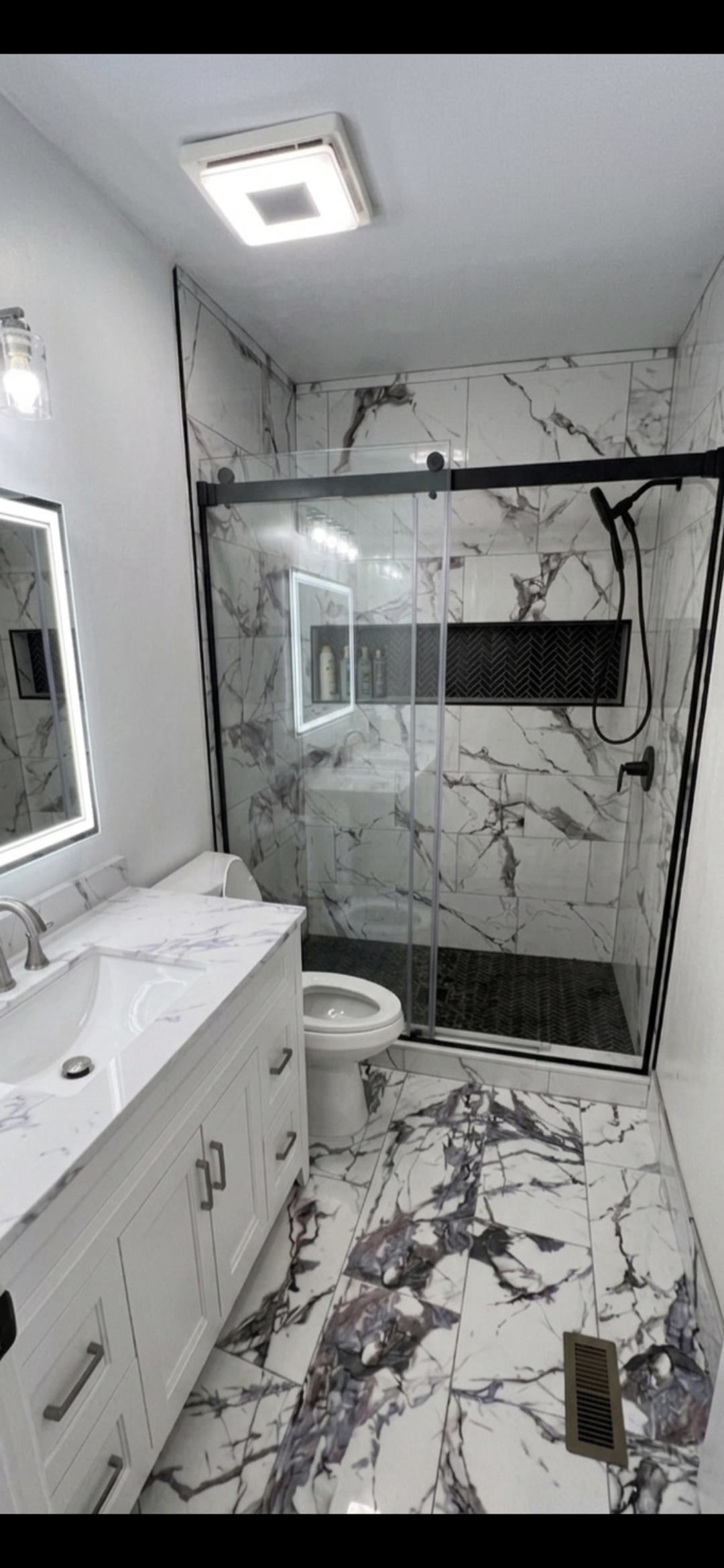 Finished bathroom remodel with marble tile walk-in shower